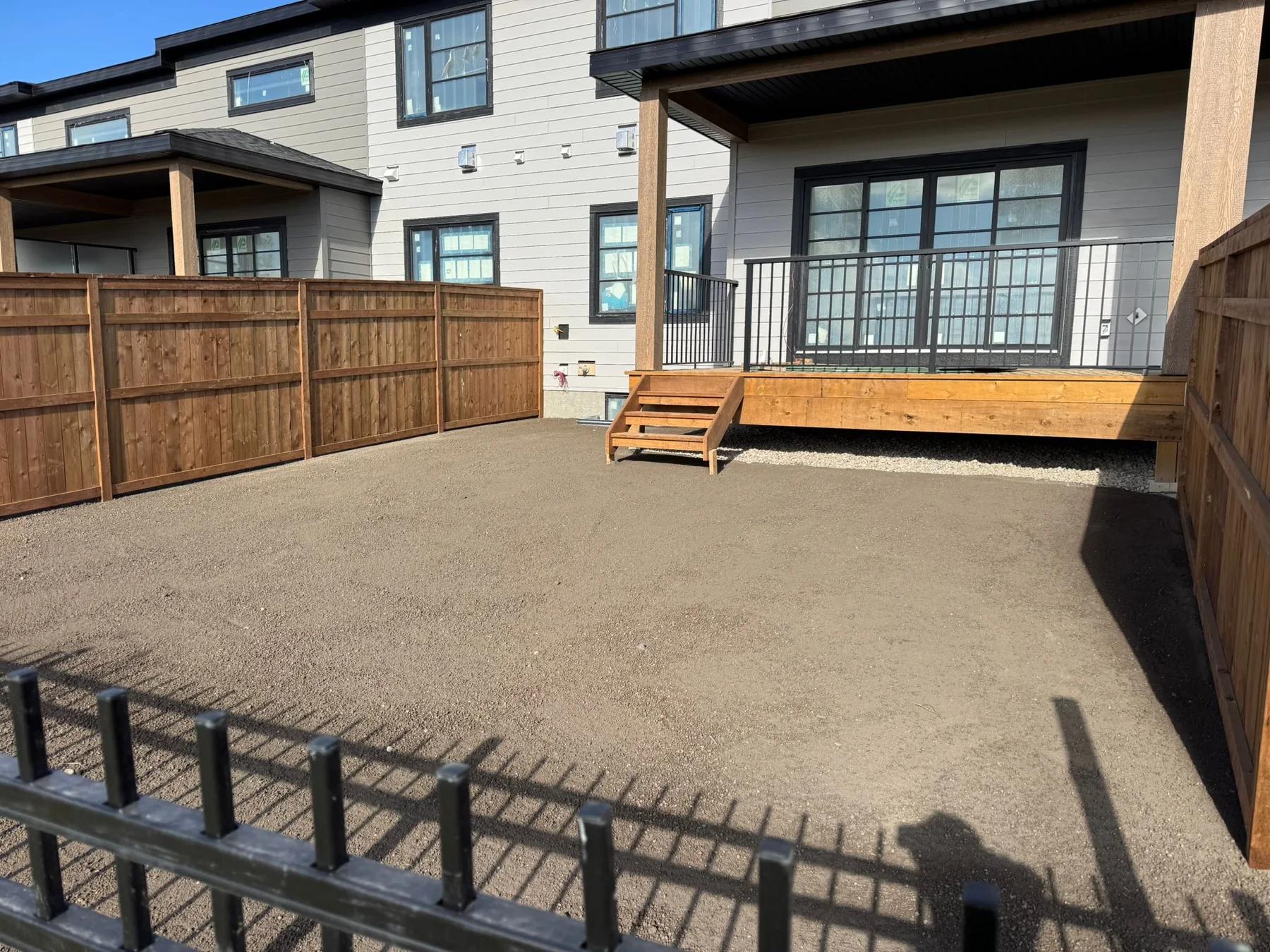 Fenced backyard with finished deck steps and prepared graded soil